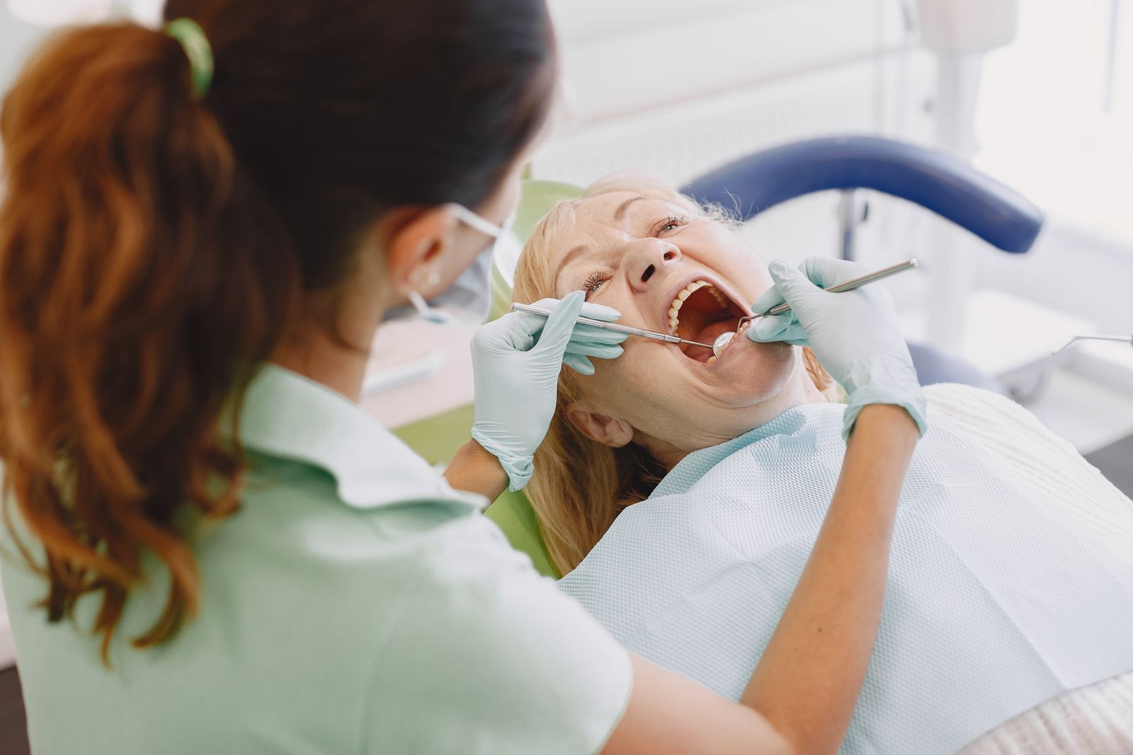Dentist carefully examining a patient