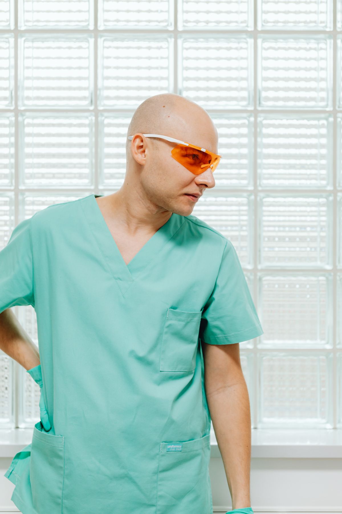 Stock portrait of a male clinician in green scrubs